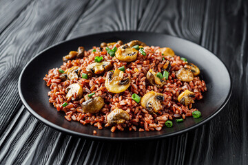 delicious red rice with mushrooms on a black wooden rustic background