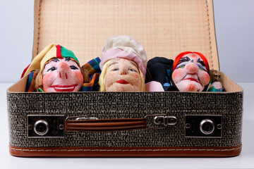 some punch puppets sitting inside a vintage suitcase