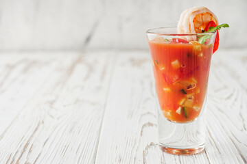 delicious summer gazpacho cocktail on a white wooden rustic background