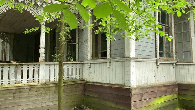 Old traditional wooden house with carved windows. Rundown house. Summer cottages of 19th century - suburb of Kyiv, Ukraine. August 1 2021.