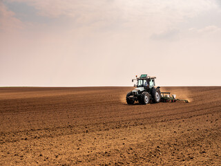 Farmer using a tractor to plant soybean seeds in a field