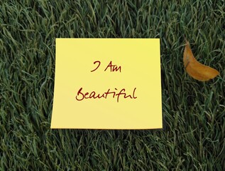 Yellow note on grass with text I AM BEAUTIFUL, self-love affirmation to boost self esteem, overcome...