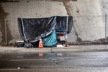 Homless shelter in the rain under a freeway bridge