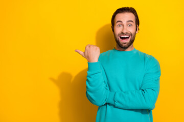 Fototapeta premium Photo of young wearing cyan stylish pullover designer guy open mouth finger point empty space new collection isolated on yellow color background
