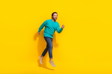 Fototapeta na wymiar Full length photo of cool funky guy dressed teal outfit jumping high running fast empty space isolated yellow color background
