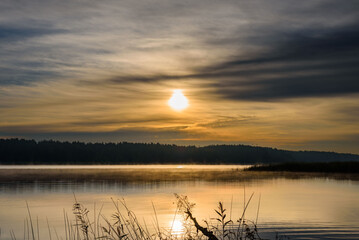 A sunrise over the river in autumn