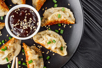 delicious fried gyoza dumplings on a black plate
