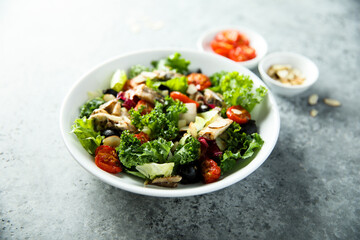 Healthy green salad with roasted tomatoes and fish