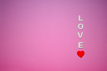 Fondo rosa con texto love y un corazon rojo