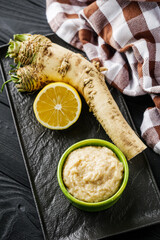 aromatic horseradish root on a black rustic wooden background