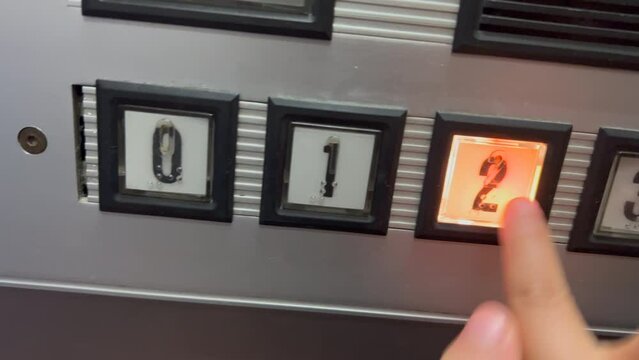 Child hand pressing old elevator buttons
