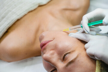 Naklejka premium Close up female face with syringe needle