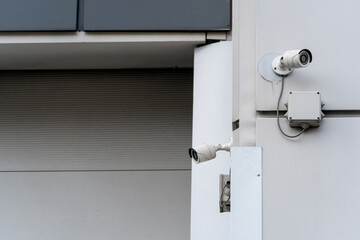 Modern surveillance cameras on the facade of the building. CCTV cameras at the entrance to the guarded parking lot. The guarded territory of a bank or prison.
