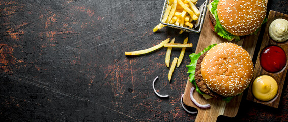 Burgers with fries and various sauces.