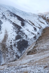 Fototapeta na wymiar Georgian mountains. Kazbegi. Snow hills, epic clouds
