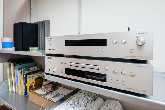 Paris, France - Dec 13, 2022: new Onkyo NS-6170 network audio player with DSD Hi-Res Audio and DSD DAB WIFI device above Onkyo C-7070 luxury CD player - all on a Vitsoe 6060 shelves 