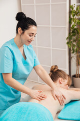 Obraz na płótnie Canvas masseur makes a therapeutic spa massage for a woman
