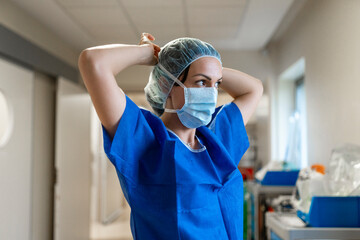 Fototapeta na wymiar Nurse putting on her face mask in a hospital