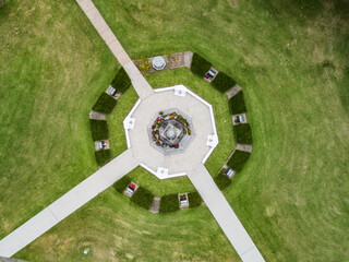 Burdekin Park cenotaph with remembrance day wreaths laid around it seen from top down aerial view