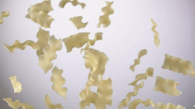 Pasta mafalde corte is flying up and rotating on a white background