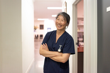 female middle aged healthcare worker with arms crossed smiling at the camera