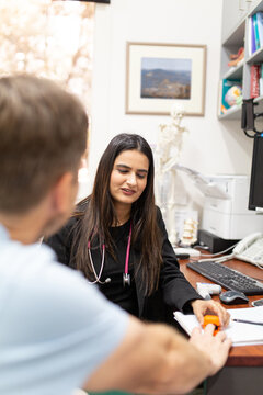Female doctor checking a male patient's pulse with an oximeter
