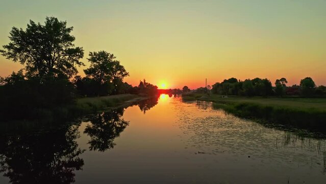 Drone Aerial Sunrise pushback low angle nature reflective shot above lake