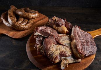 Smoked pork and sausage on wooden board