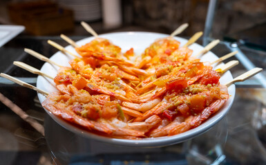 Typical snack of Basque Country, pinchos or pinxtos skewers with small pieces different fish and sea food, served in bar in San-Sebastian or Bilbao, Spain