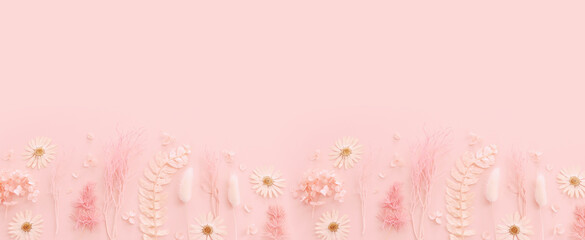 Fototapeta premium Top view image of pink dry flowers over pastel background .Flat lay