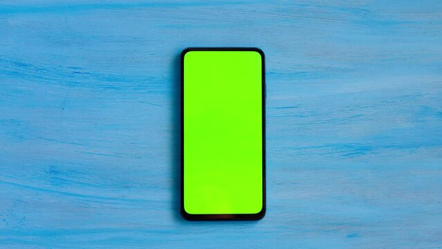 Smartphone with green screen on blue background.