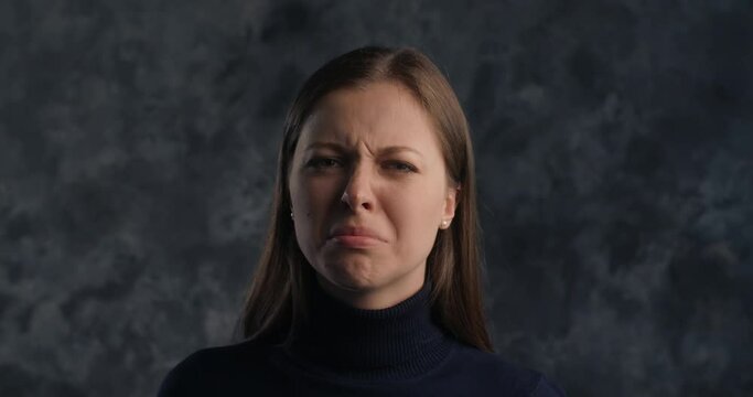 Portrait of actor's reaction: woman acts smelling something bad