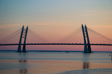 Beautiful cable-bridge on the sunset over the river. Perfect for posters, post cards, covers and wallpapers.
