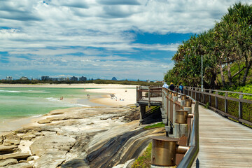 Timber boardwalk and pandanus palm trees by the sea at Caloundra, Queensland.