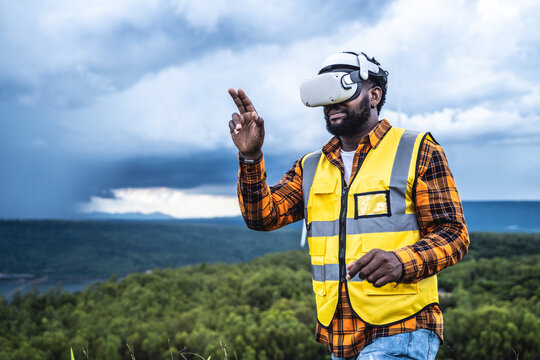 Portrait of engineer African American man working with VR headset in wind turbine farm. - Powered by Adobe