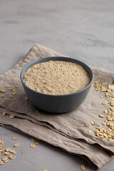 Organic White Oat Flour in a Bowl on a gray background, low angle view.