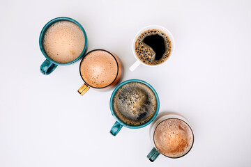 A set of mugs with different coffees on a white background. Flat lay