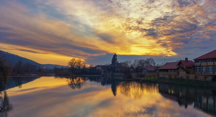 Fototapeta na wymiar Beautiful sunset on a quiet river. Dramatic cloudy sky reflected in calm water. Romantic mood