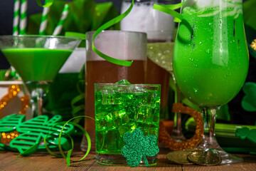 St Patrick's Day bar menu background. Set various golden, green beer glasses, different cocktails and drinks, with St. Patrick's Day party decor and accessories, on dark wooden background