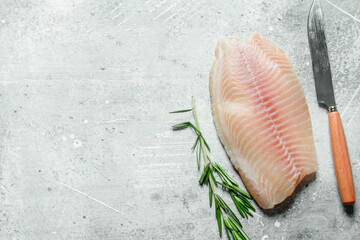 Fish fillet with knife and rosemary.