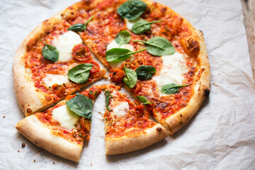 Pizza with tomato sauce, mozzarella and spinach 