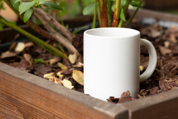 White mug in the garden. - 562098729
