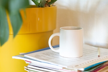 A white mug on a stack of papers