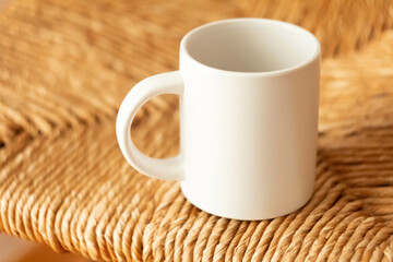 A white mug on a wicker chair