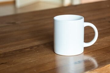 White mug on the wooden table. - 562099142