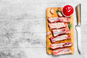 Raw ribs with tomato sauce and fragrant rosemary .