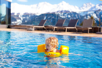 Child in outdoor swimming pool of alpine resort