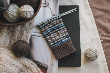 Hand knitted socks with needles and yarn balls. Concept for handmade and hygge slow life.