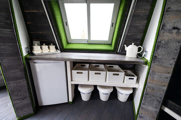 Small kitchen elements in wooden summer house. Refrigerator, kettle, hot drinks, crockery and...
