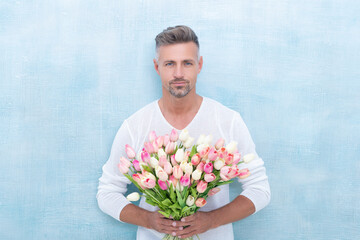adult man with spring tulips. man with spring tulips in studio. man with spring tulips